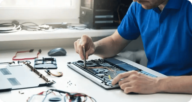 Mann mit Werkzeug schraubt einen Laptop auseinander
