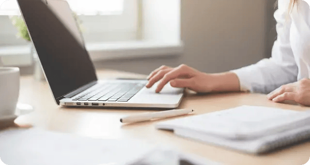 Frau sitzt vor Laptop
