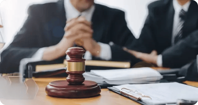 Männer am Tisch mit einem richterlichen Hammer und Dokumenten