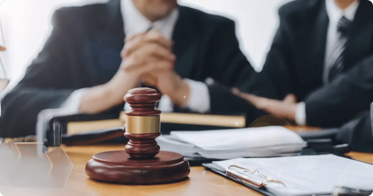 Männer am Tisch mit einem richterlichen Hammer und Dokumenten