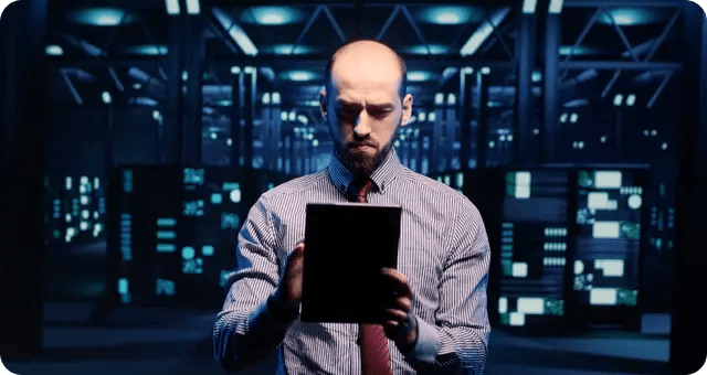 Mann mit Tablet in einem dunklen Serverraum