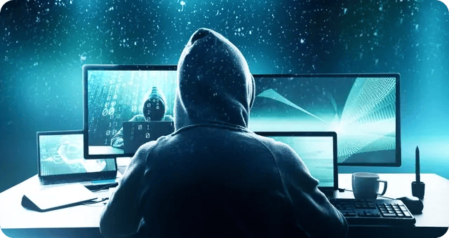 Ein Hacker vor mehreren Bildschirmen